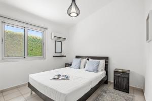 a bedroom with a bed with two slippers on it at Ivy Blue Villa by Nomads - Short Walk to Coral Bay in Peyia +17 photos