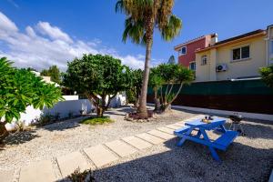 a blue picnic table in front of a house at Ivy Blue Villa by Nomads - Short Walk to Coral Bay in Peyia