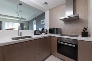 una cocina con fregadero y microondas en Cozy 1BR with balcony great view, Damac Towers, en Dubái