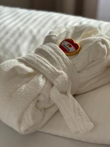 a white towel with a heart on it on a bed at Alpin Apartments am Dorfbrunnen JUNIOR SUITE in Steinach am Brenner