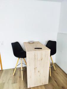 einen Holztisch mit zwei Stühlen in einem Zimmer in der Unterkunft Stilvolles Apartment für 2 - Schwäbische Alb in Heidenheim
