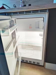 einem leeren Kühlschrank mit offener Tür in der Küche in der Unterkunft Stilvolles Apartment für 2 - Schwäbische Alb in Heidenheim