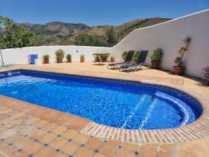 a swimming pool in a yard with a patio at Casa Laura in Almuñécar