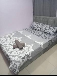 a bed with a black and white blanket and pillows at GR Homestay at Ayuman Suites Gombak in Kuala Lumpur