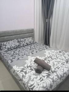 a bed with a black and white blanket on it at GR Homestay at Ayuman Suites Gombak in Kuala Lumpur