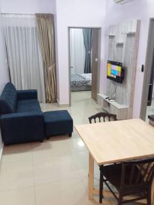 a living room with a blue couch and a table at GR Homestay at Ayuman Suites Gombak in Kuala Lumpur