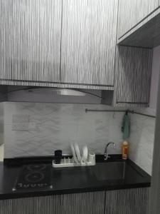 a kitchen counter with a sink and a stove at GR Homestay at Ayuman Suites Gombak in Kuala Lumpur