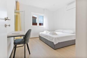 a white bedroom with a bed and a desk at Exclusive Resort Vista Hills in Sevid +22 photos