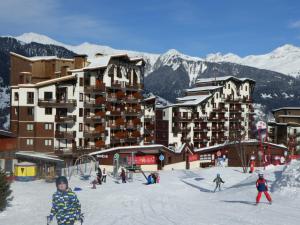 a group of people skiing in the snow in front of a hotel at Studio lumineux avec balcon sud, plein cœur de La Tania, skis aux pieds - FR-1-513-43 in La Tania +5 photos