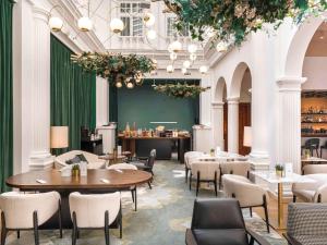 restauracja ze stołami i krzesłami oraz zieloną ścianą w obiekcie Rezydent Hotel Sopot - MGallery Collection w mieście Sopot