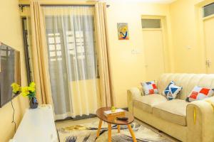 a living room with a couch and a table at Farrey Homes 1 Br Kitengela in Nairobi