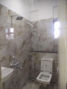 a bathroom with a toilet and a sink at Paradise Living in Bangalore +23 photos
