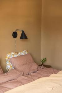 a bedroom with a bed with a lamp and a pillow at Etagevåning på Stora torget in Visby