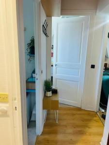 a hallway with a white door and a potted plant at Centralised Apartment in Paris in Paris