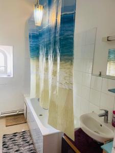 a bathroom with a sink and a shower curtain at Centralised Apartment in Paris in Paris