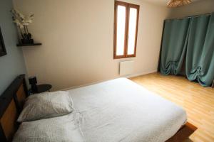 Un dormitorio con una cama blanca y una ventana. en Le petit Monlogis - Calme - Wi-Fi, en Angulema 3 fotos más