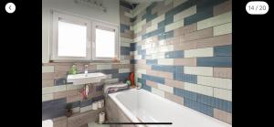 a bathroom with a tub and a sink at Attractive comfortable room in friendly house in Hastings +12 photos