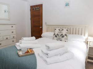 a bedroom with a white bed with towels on it at Heron in St Ives