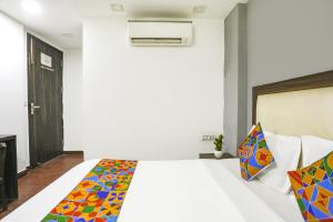 1 dormitorio con cama blanca y almohadas coloridas en Via The Arrow, en Nueva Delhi