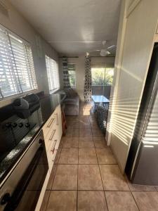 una cocina con un gran suelo de baldosas y ventanas en 58 Chakas Rock Chalets, en Ballito