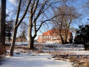 a house in the snow with trees in front of it at Schloss Pütnitz - Kanuspezial ab 4 Ü 06 Jan bis 29 April in Ribnitz-Damgarten