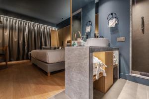 a bathroom with a sink and a bed in a room at Magnes Hotel in Volos
