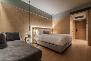 a bedroom with a large bed and a couch at Magnes Hotel in Volos