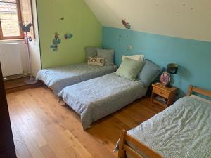 a bedroom with three beds in a room at La Maison du Pas Trop in Athie