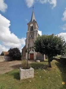 an old church with a tower with a clock on it at La Maison du Pas Trop in Athie