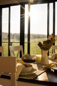 a dining table with a view of the water at The Old Farm Cottage, Mount Torrens in Mount Torrens