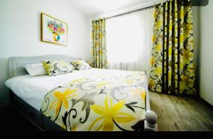a bedroom with a bed with a floral bedspread and a window at Boulevard residence in Alba Iulia
