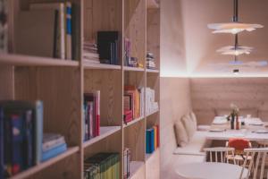 ein Bücherregal mit Büchern und einem Tisch in einem Zimmer in der Unterkunft O'Mama family time - am Eggerhof in Mühlbach