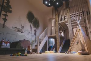 een kinderkamer met een speeltuin met een speeltent bij O'Mama family time - am Eggerhof in Mühlbach
