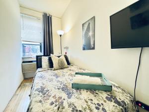 une chambre avec un lit et une télévision à écran plat dans l'établissement UES Manhattan ROOM #2 in Shared Apartment, à New York