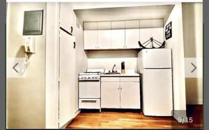 une cuisine avec des armoires blanches et un réfrigérateur blanc dans l'établissement UES Manhattan ROOM #2 in Shared Apartment, à New York