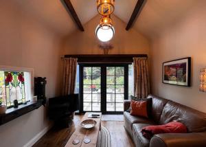 a living room with a leather couch and a table at Little Syke in Nun Monkton