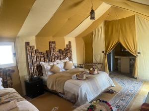 a bedroom with a large bed in a tent at Sahara Majestic Luxury Camp in Merzouga +37 photos
