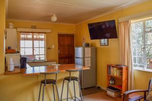 Il comprend une cuisine équipée d'un comptoir et d'un réfrigérateur. dans l'établissement Dabchick Cottage, à Dullstroom 34 autres photos