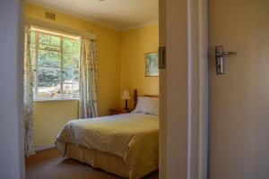 une chambre avec un lit et une fenêtre dans l'établissement Dabchick Cottage, à Dullstroom