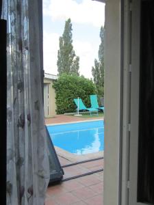 a view of a swimming pool from a window at Galinat in Culmont