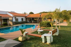 a house with a swimming pool in a yard at Chacara Las Palomas in Presidente Epitácio