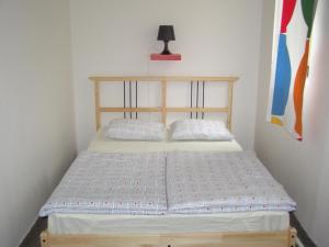 een kleine slaapkamer met een bed met een houten hoofdeinde bij Hostel Praha Ládví in Praag