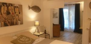 a bedroom with a bed and a painting on the wall at Pomme de Pin et Mimosa in Grand-Village-Plage +25 photos
