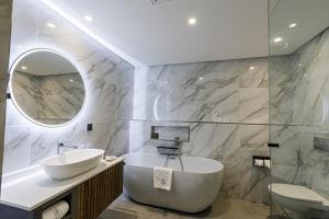 ダル・エス・サラームにあるSea Cliff Hotelのバスルーム(バスタブ、シンク、鏡付)