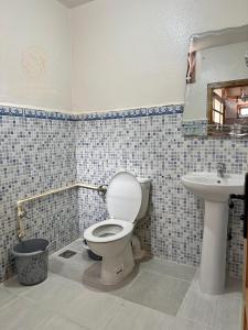 a bathroom with a toilet and a sink at Appartements Meublés servitio 1 in Laayoune