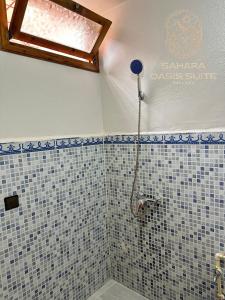 a bathroom with a shower with blue and white tiles at Appartements Meublés servitio 1 in Laayoune +5 photos