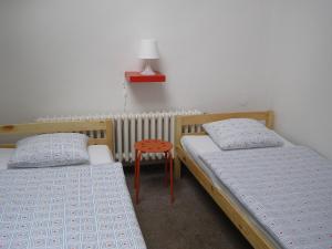 a bedroom with two beds and two lamps at Hostel Praha Ládví in Prague