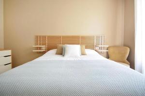 a bedroom with a large white bed and a chair at La Casa De Roma in Cambados