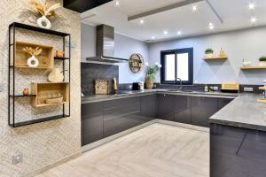 a large kitchen with a sink and a counter at Villa Emeraude-Joyaux de Provence in Saint-Étienne-du-Grès