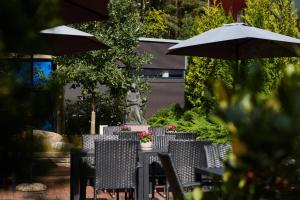 a table with chairs and a statue under an umbrella at Hostel Linnasmäki in Turku